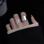 Silver wide-face smooth adjustable ring from Yeha Maison, featuring a sleek, polished design on a jewelry display.
