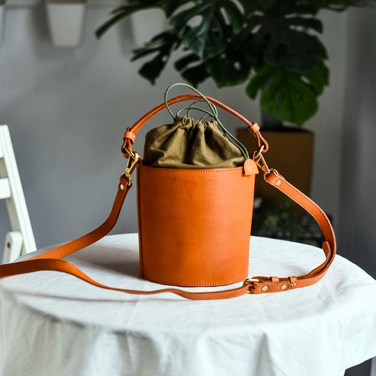 Women's handcrafted leather bucket bag by Yeha Maison, featuring a stylish design with a drawstring closure and shoulder strap.