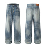 Men's light wash wide-leg jeans by Yeha Maison with button fly and relaxed fit, shown hanging on a wooden background.